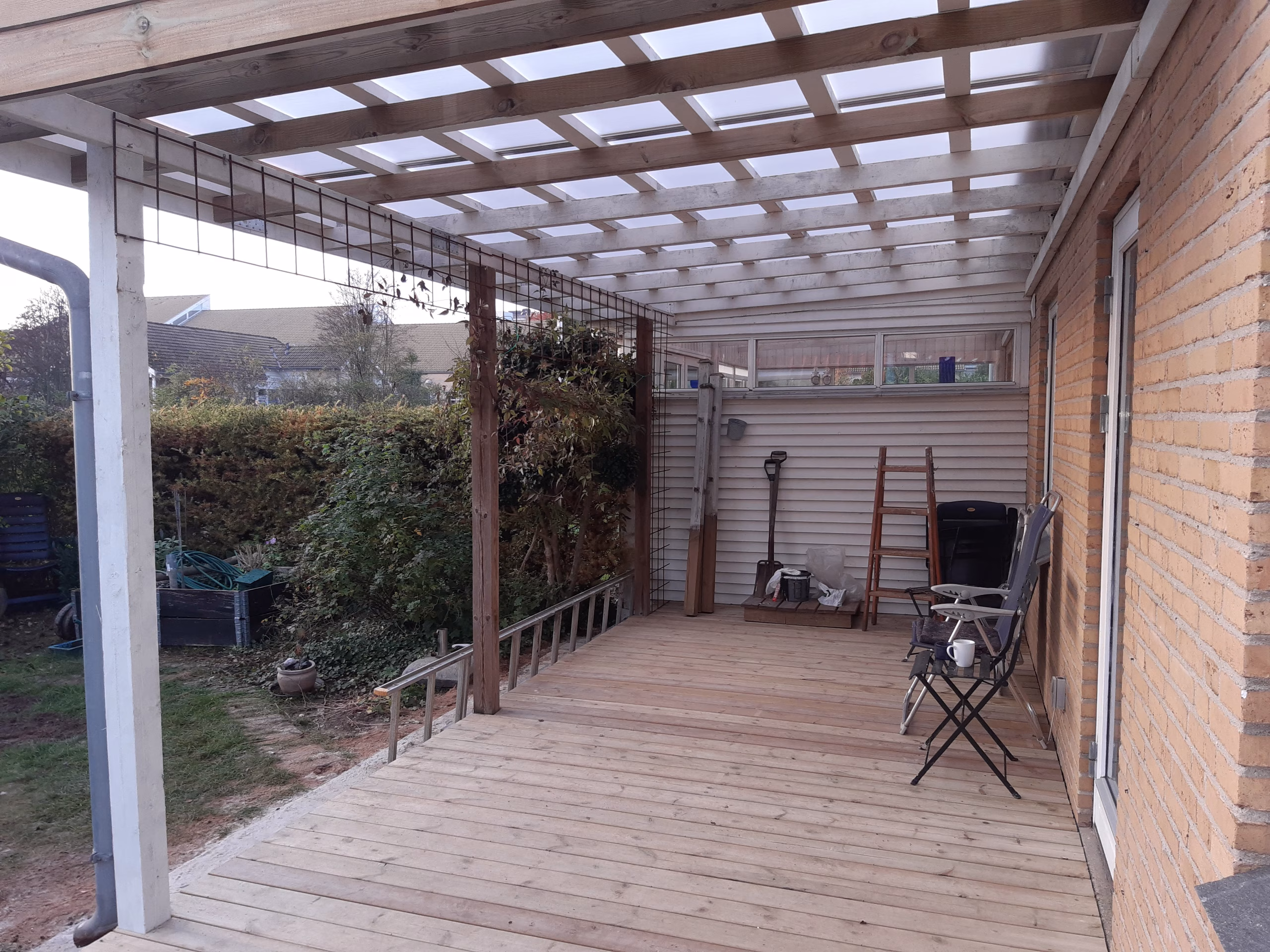 Udvidet træterrasse og terrasseoverdækning i Silkeborg Montering af træterrasse med trykimprægnerede terrassebrædder i Silkeborg